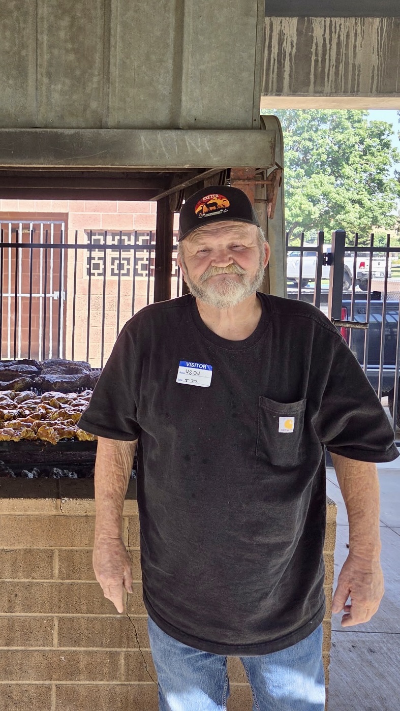 A volunteer at the barbecue pit during a community event